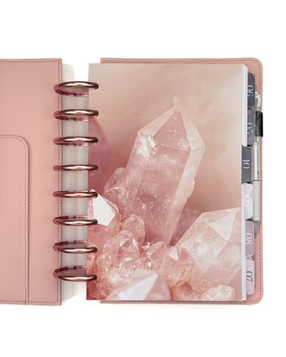 A pink quarts crystal design on a planner with Rose Gold discs and Blush Vegan Leather Cover. 