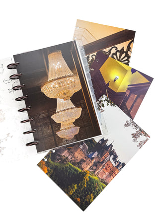 Open Jane’s Agenda discbound planner with dark metallic discs and monthly tabs, displaying a chandelier dashboard alongside coordinating dashboards featuring an ornate staircase, vintage interior, and autumn castle scenes.
