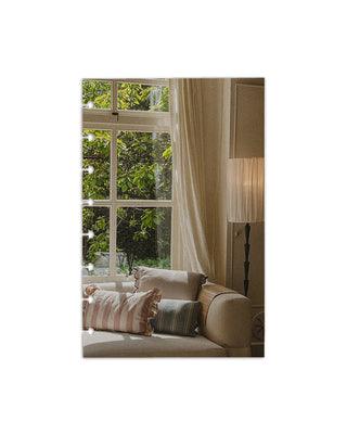 A cardstock planner dashboard depicting and image of a living room with a beige sofa, striped cushions, and a large window with white curtains.