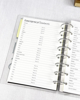Emergency contacts list in a discbound planner on a light gray surface.