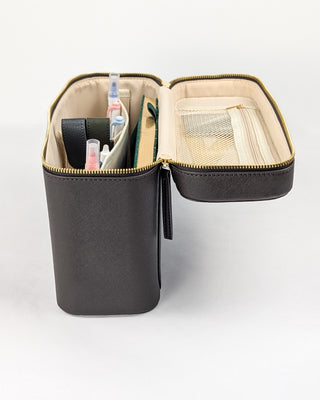 A side view of a chocolate brown vegan leather train case with pens and other accessories added.