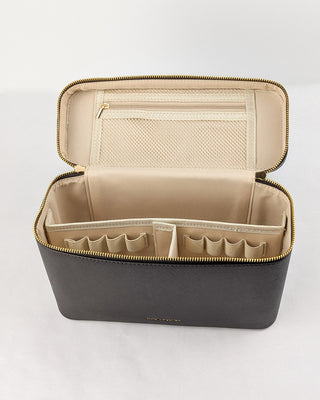 The inside of a chocolate brown vegan leather train case with a mesh zipper pouch and detachable dividers featuring eight pen loops.