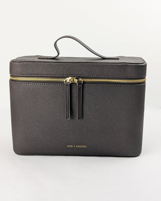 Chocolate brown vegan leather train case with top handle and gold metal hardware.