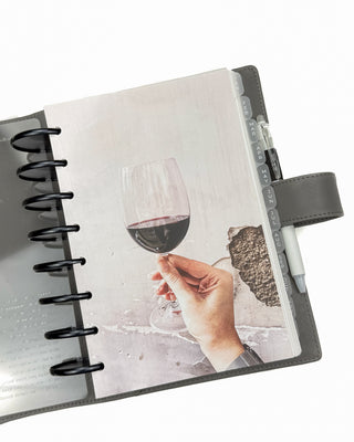 Jane's Agenda gray discbound planner vegan leather cover detail shot – wine photography dashboard, black metal binding discs, frosted monthly tabbed dividers, and magnetic snap closure