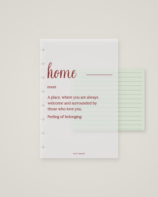 Frosted discbound planner dashboard featuring the word “home” in burgundy script with a definition about belonging and being surrounded by loved ones, layered over a pale green lined page.
