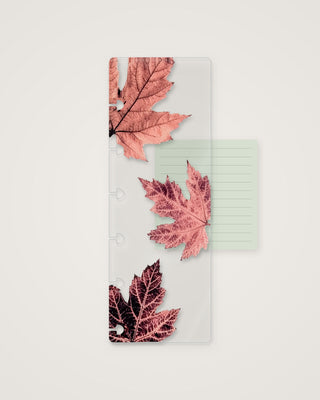 Clear discbound planner page finder featuring three oversized autumn maple leaves in soft coral, dusty pink, and deep burgundy tones, with a pale green lined notepad tucked behind it.