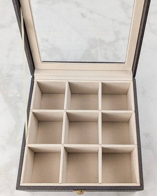 Brown synthetic leather accessories case interior view of nine square compartments.