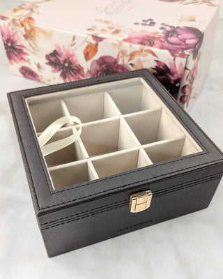 Brown synthetic leather accessories case with a floral box sitting in the background.