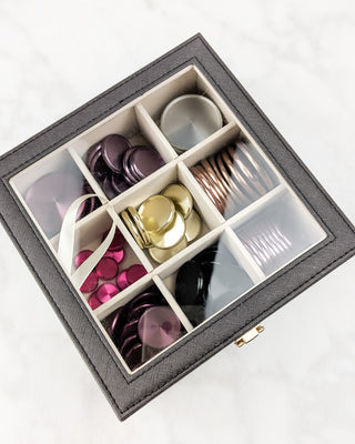 Brown synthetic leather accessories case overhead view of contents through the transparent lid.