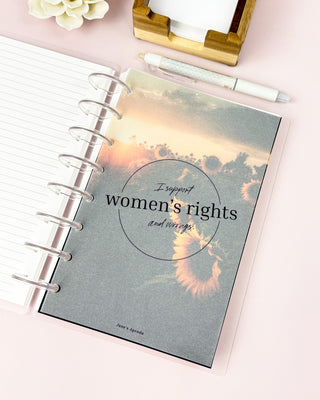 a discbound planner with a vellum dashboard featuring 'I support women's rights and wrongs' text lying on a pink background