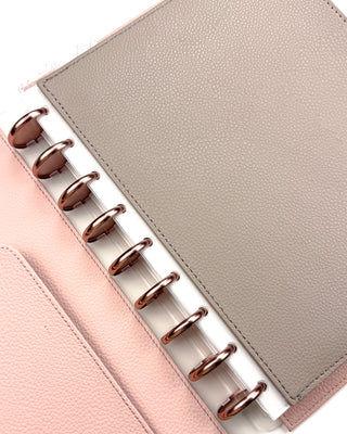 Close up of the plastic spine of the taupe brown zipper pouch snapped onto Rose Gold discs in a Classic size. 