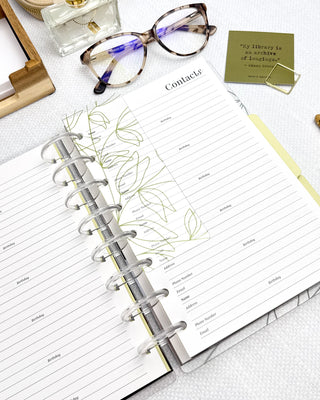 Open discbound planner with decorative elements on a white surface.