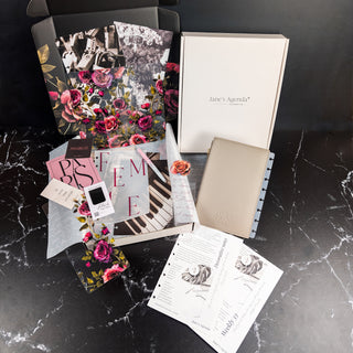 Collection of Jane's Agenda products on a dark marble surface