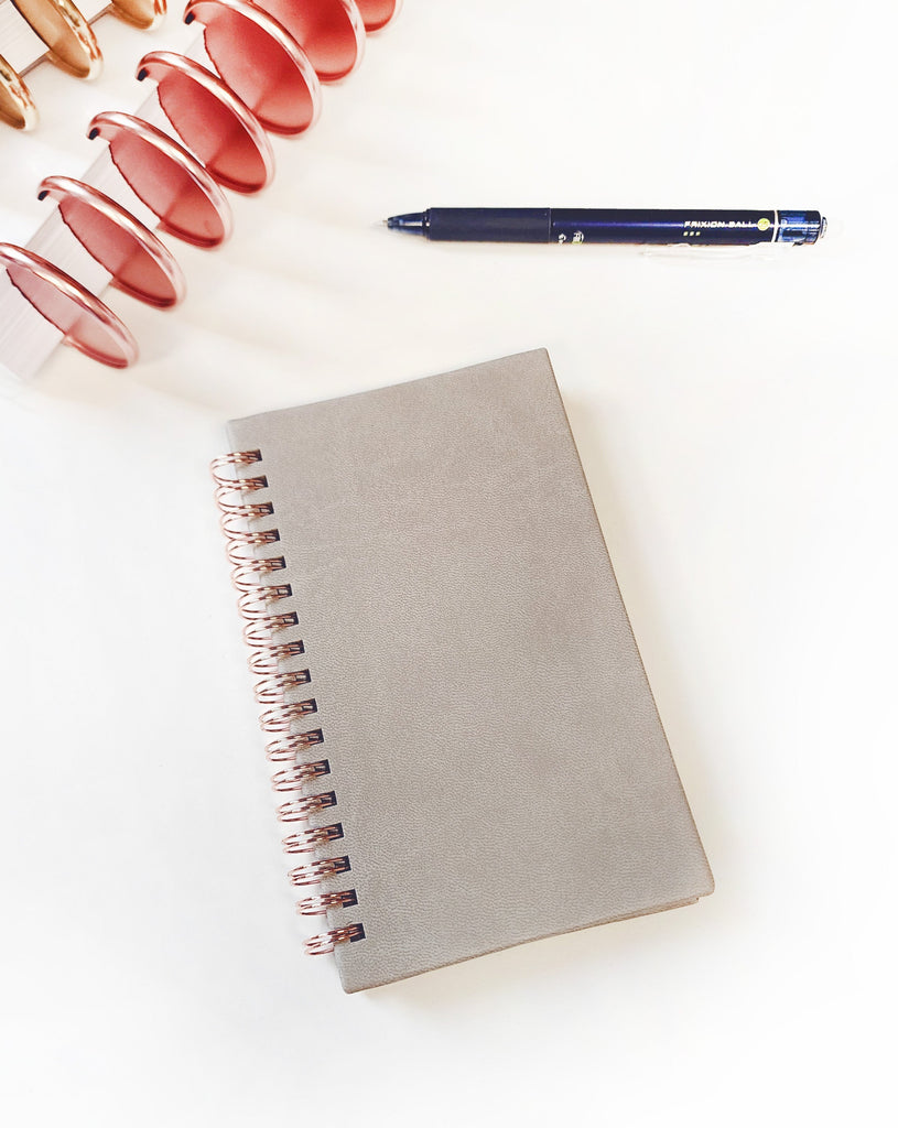 This mini dot grid notes notebook features rose gold twin loop spiral binding with a soft gray vegan leather hardcover. by Janes Agenda.